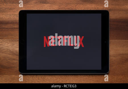 The website of Netflix is seen on an iPad tablet, which is resting on a wooden table (Editorial use only). Stock Photo