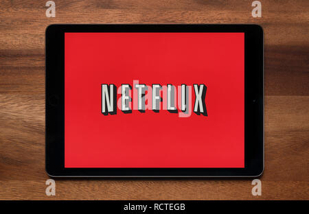 The website of Netflix is seen on an iPad tablet, which is resting on a wooden table (Editorial use only). Stock Photo