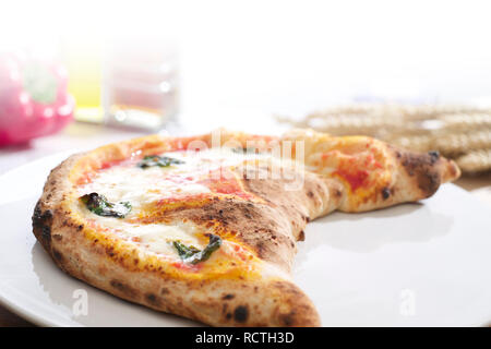 Whole freshly baked calzone pizza on plate Stock Photo