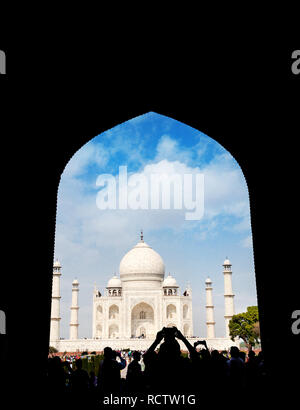 Taj Mahal view in black arch silhouette with tourist taking picture with cellphone in Agra, Uttar Pradesh, India. Copy space, book cover template. Stock Photo