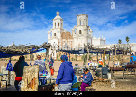 Native American food vendors cook frybread for tourists visiting the historical Mission San Xavier del Bac, a Spanish Catholic Mission near Tucson, AZ Stock Photo