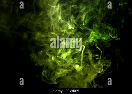 Dense multicolored smoke of    green colors on a black isolated background. Background of smoke vape Stock Photo
