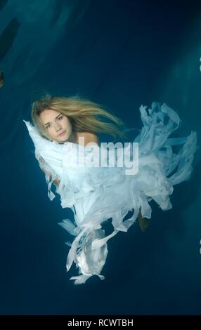 Woman presenting underwater fashion in a pool Stock Photo