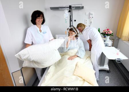 Hospital. Nurses making the bed of a female patient Stock Photo - Alamy