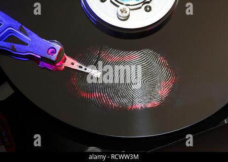 Computer hard drive, opened, read-write head on the disk, fingerprint on the disc, digital fingerprint, symbolic image Stock Photo