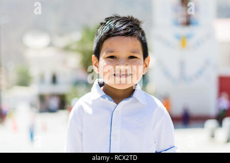 Boy in white shirt outdoors smiling without teeth Stock Photo