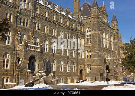 Historic building on Georgetown University campus in winter. Snow covered ground and tree branches after a major snowfall in the Washington DC, USA. Stock Photo