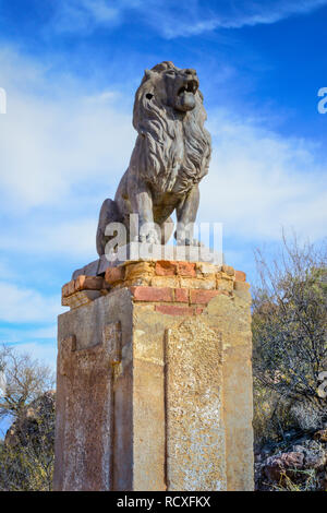 A sculpture of a guardian lion atop a pillar on the grounds At the historical Mission San Xavier del Bac, a Spanish Catholic Mission near Tucson, AZ Stock Photo