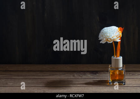 Aromatic reed freshener, Fragrance Diffuser Set of bottle with aroma sticks (reed diffusers) on dark wood wall background. Stock Photo