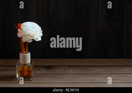 Aromatic reed freshener, Fragrance Diffuser Set of bottle with aroma sticks (reed diffusers) on dark wood wall background. Stock Photo
