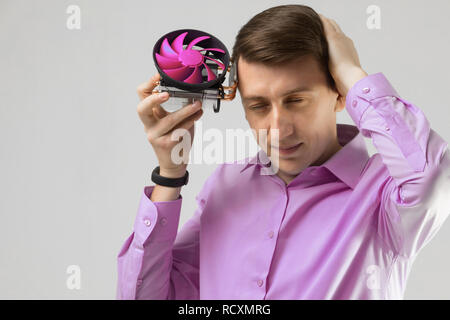 young man leaned against the head of the cooler from computer isolated on a light background Stock Photo