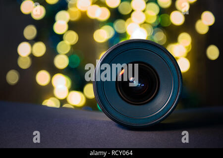 Close up of camera lens front element with defocused bokeh balls in the background. Photography equipment Stock Photo