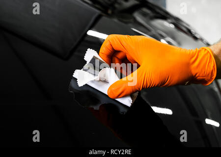 Car polish wax worker hands polishing car. Buffing and polishing vehicle. Car detailing. Man holds a polisher in the hand and polishes the car. Tools  Stock Photo