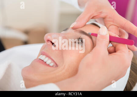 Beautiful woman gets eyebrow correction procedure Stock Photo