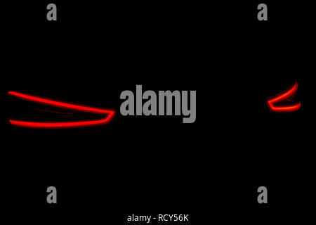 Rear car lights on a black background. Cars light trails. Night city road with traffic headlight. Light up road by vehicle. Car lights at night Stock Photo