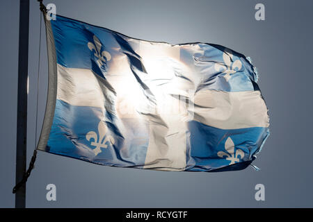 The provincial flag of Quebec, Canada. The blue and white flag bears a cross and four fleur-de-lys emblems. Stock Photo