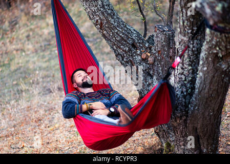 Man lying in a hammock and relaxing in the nature Stock Photo