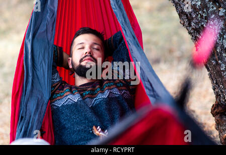 Man relaxing in a hammock on a hiking trip Stock Photo