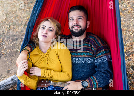 Loving couple lying in a hammock on a picnic outdoors Stock Photo