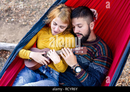 Loving couple lying in a hammock on a picnic outdoors Stock Photo