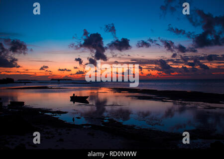 Sunset reflected on the water surface. Beautiful landscape with the boat. Stock Photo