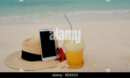 Mobile Internet anywhere in the world, concept. Using the Internet and your smartphone even on a remote tropical island. Straw hat, pineapple juice an Stock Photo