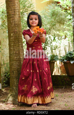 Young Indian girl child wearing traditional dress sari, full skirt for  Onam, Vishu festival Kerala India. Happy beautiful daughter making flower  bed Stock Photo - Alamy