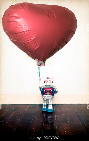 silver  robot holding red balloon standing on old wooden floor  copy space