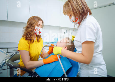 Image of dental checkup being given to little girl by dentist with assistant near by at the madical office Stock Photo