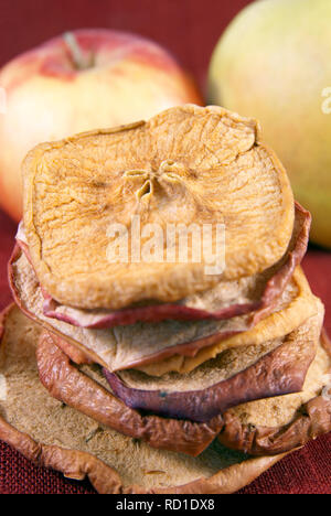 Pyramid of dried apple pieces and two fresh apples on the background Stock Photo