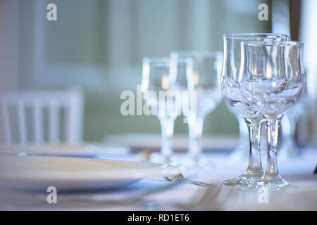 Clean table setting for fine dining with focus on two crystal glasses for water and wine, ready for guests at an event, wedding or at a restaurant Stock Photo