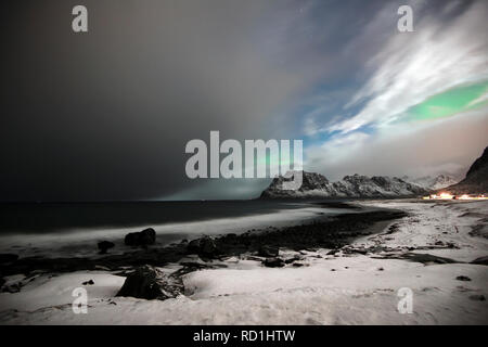 Northern lights and a polar low approaching land, Utakleiv, Lofoten, Nordland, Norway Stock Photo