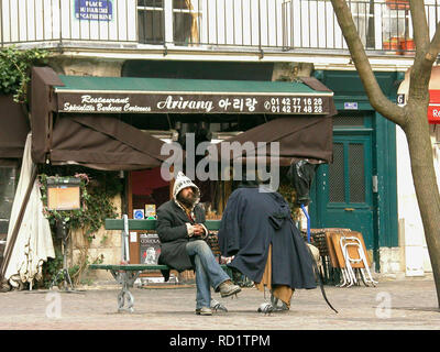 Eccentric character sitting on bench in Place du Marché Ste-Catherine, le Marais, Paris, France Stock Photo