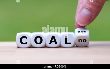 Using coal for energy? Hand flips a dice and changes the word "yes" to "no" Stock Photo