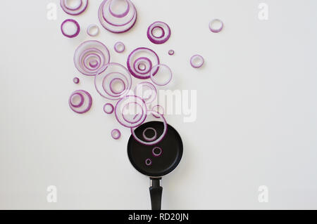 Conceptual red onion ring steam over a frying pan Stock Photo