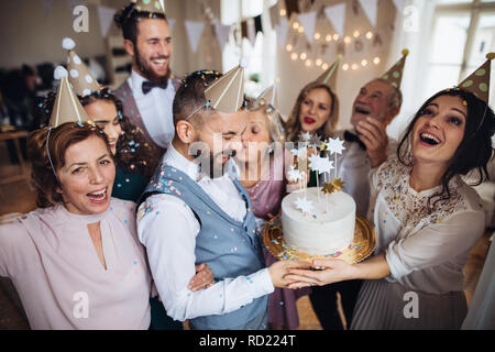 A portrait of multigeneration family with a cake on a indoor birthday party. Stock Photo