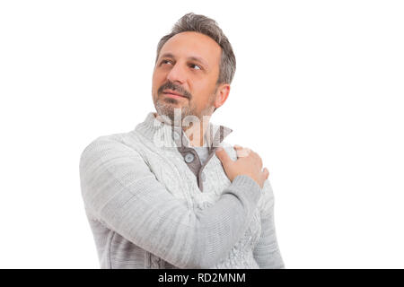 Close-up portrait of male person looking up touching shoulder wearing grey knitted sweater isolated on white background Stock Photo
