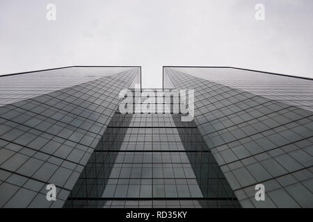 Low angle shot looking up onto a modern large glass office building Stock Photo