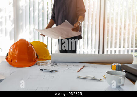 Architect working in a office. Engineer holding blueprint in office, architectural concept Stock Photo