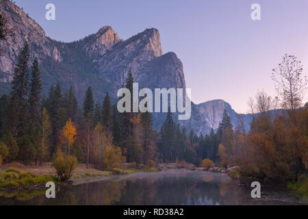 The Three Brothers reflect at morning in the Merced River in Yosemite National Park. California, USA. Fall Stock Photo