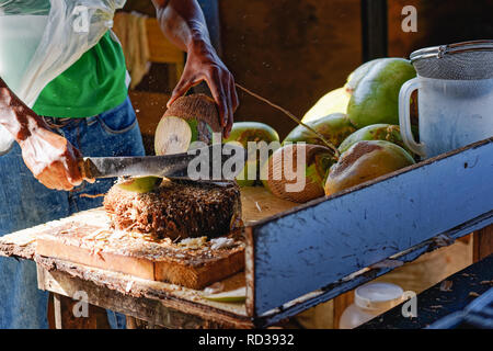 man cutting open fresh coconut to extract the water inside Stock Photo