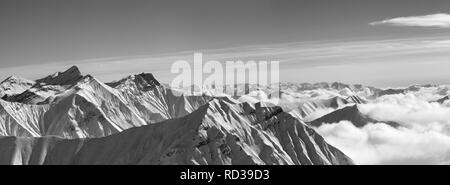 Black and white panorama of snowy mountains in clouds at nice winter evening. Caucasus Mountains, Georgia, region Gudauri. Stock Photo