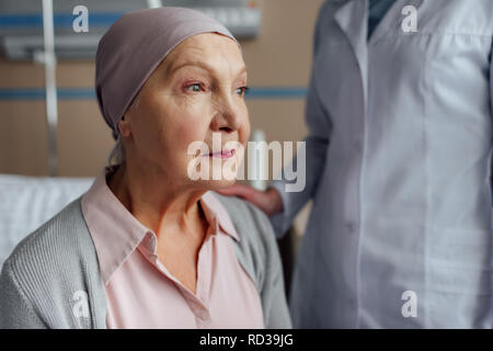 doctor consoling upset senior woman with cancer in hospital Stock Photo