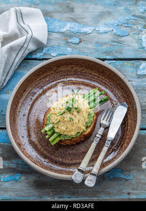 Toasted bread with scrabled eggs and avocado, copy space Stock Photo