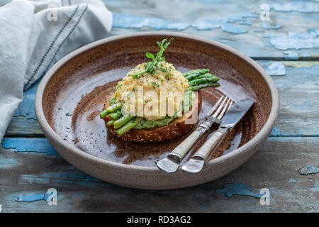 Healthy breakfast with scrambled eggs, avocado and asparagus, close view Stock Photo