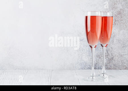 Rose champagne glasses in front of stone wall. With space for your text Stock Photo
