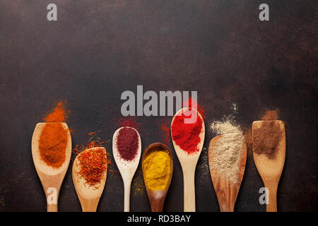 Set of various spices in spoons on stone background. Top view with space for your recipe. Flat lay Stock Photo