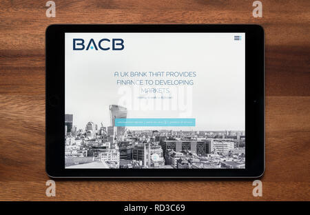 The website of British Arab Commercial Bank (BACB) is seen on an iPad tablet, which is resting on a wooden table (Editorial use only). Stock Photo