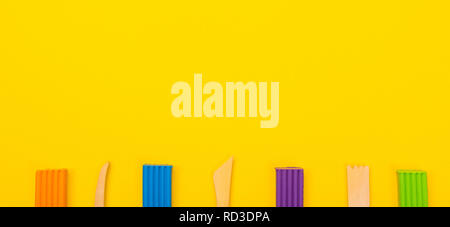 Set of colorful plasticine isolated on yellow background Stock Photo