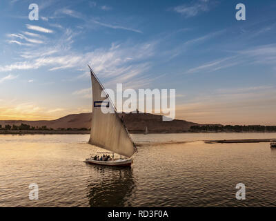 Tourist taking a ride in a Felucca boat in Luxor Egypt on the NIle River Stock Photo